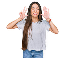 Young hispanic girl wearing casual white t shirt showing and pointing up with fingers number eight while smiling confident and happy.