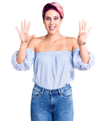 Young beautiful woman with pink hair wearing casual clothes showing and pointing up with fingers...