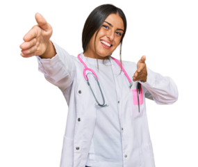 Beautiful hispanic woman wearing doctor uniform and stethoscope looking at the camera smiling with open arms for hug. cheerful expression embracing happiness.