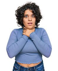Young hispanic woman with curly hair wearing casual clothes shouting and suffocate because painful...