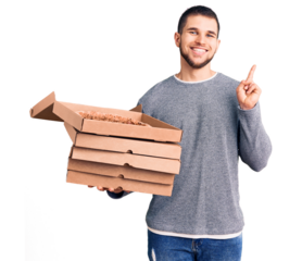 Young handsome man holding delivery italian pizza boxes surprised with an idea or question pointing finger with happy face, number one