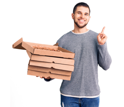 Young handsome man holding delivery italian pizza boxes surprised with an idea or question pointing finger with happy face, number one