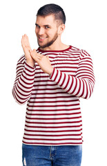 Young handsome man wearing striped sweater clapping and applauding happy and joyful, smiling proud...