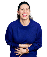 Young hispanic woman wearing casual clothes smiling and laughing hard out loud because funny crazy joke with hands on body.