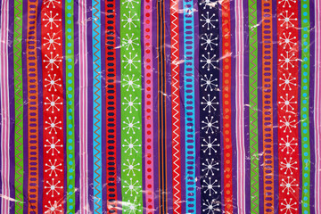 White snowflakes and geometric patterns on a multicolored background crumbled wrapping paper. Christmas Holiday concept.