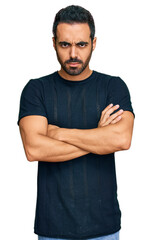 Young hispanic man wearing casual clothes skeptic and nervous, disapproving expression on face with crossed arms. negative person.