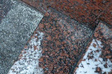 Deicing chemicals on steps in winter. Salt grains on icy stairs in cold season. Slippery surface sprinkled with technical salt and calcium. Prevent slipping concept