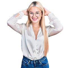 Beautiful blonde woman wearing elegant shirt and glasses relaxing and stretching, arms and hands behind head and neck smiling happy