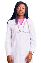 Young african american woman wearing doctor stethoscope relaxed with serious expression on face. simple and natural looking at the camera.