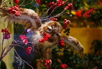 Stuffed owl on a branch with red berries - Powered by Adobe
