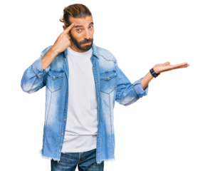 Attractive man with long hair and beard wearing casual denim jacket confused and annoyed with open palm showing copy space and pointing finger to forehead. think about it.