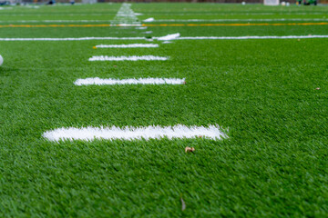 Synthetic turf field under construction with lines and graphics being installed.	 - Powered by Adobe