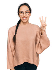 Young hispanic girl wearing casual clothes and glasses showing and pointing up with fingers number three while smiling confident and happy.