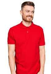 Obraz premium Young redhead man wearing casual clothes looking away to side with smile on face, natural expression. laughing confident.