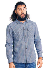 Young arab man wearing casual clothes in shock face, looking skeptical and sarcastic, surprised with open mouth