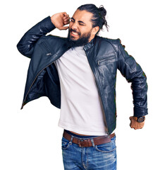 Young arab man wearing casual leather jacket stretching back, tired and relaxed, sleepy and yawning...