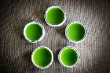 Circle of five green tea matcha drinks in a group