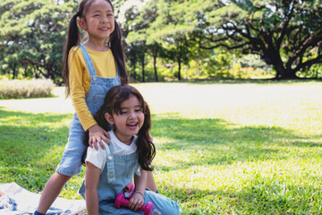 Fototapeta premium Little girls playing on sunny summer day in the park, holiday relaxation concept