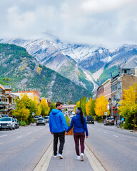 Banff village in Banff National Park Canada Canadian Rockies during the Autumn fall season. A couple of men and women on vacation in Banff Canada walking in the streets of the village