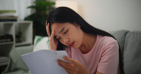 Portrait of Young Asian Woman having financial problems paychecks paper receipt bill statement...