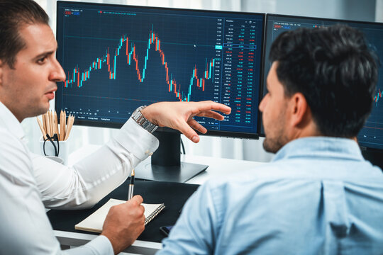 Investor stock office worker analyzing investment business trend on dynamic exchange rate database graph with monitor screen. Sharing information profit and loss in current situation crisis. Sellable.