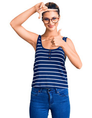 Young beautiful woman wearing casual clothes and glasses smiling making frame with hands and fingers with happy face. creativity and photography concept.