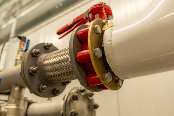 The interior of a mechanical room and a domestic potable water system with valves and connecting...