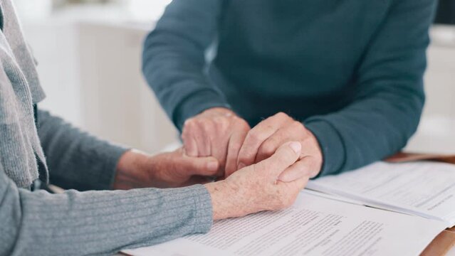Holding hands, stress and finance with a senior couple closeup in their home for accounting or budget. Insurance, tax or debt with an elderly man and woman reading information for pension or will