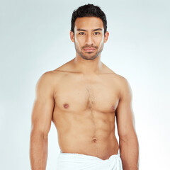 Fototapeta premium Body, chest and portrait of asian man in a towel in studio for cleaning, hygiene and care on white background. Face, confidence muscular Japanese model with glowing skin grooming results after shower