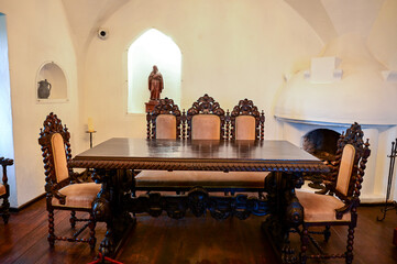 Antique table with antique chairs in the old walls of the Dracula Castle or Bran Castle, Törzburg...