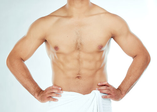 Body, closeup and fitness man in a towel in studio for shower, wellness or grooming on white background. Chest, stomach and male model relax in a bathroom for cosmetic, care or cleaning with sixpack
