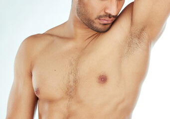 Body, closeup and man smelling armpit in studio for wellness, hygiene or control on white...