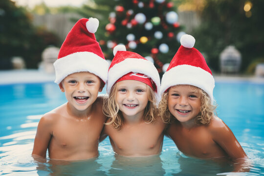 Happy group of kids in santa hat celebrating christmas in swimming pool , winter season and christmas celebration on southern hemisphere or Australia concept image