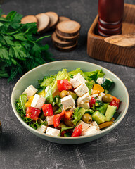 Portion of fresh greek salad on grey background