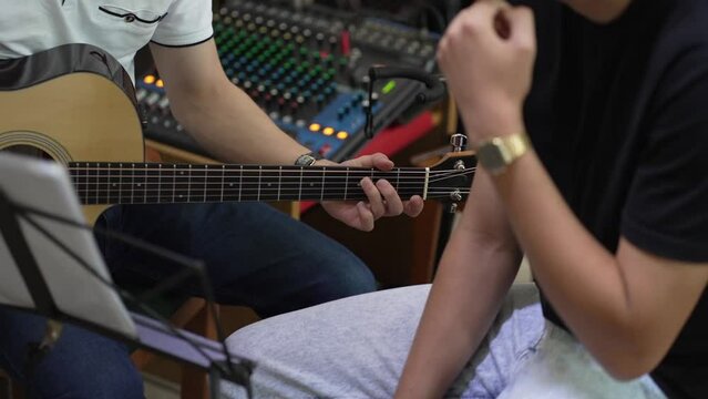 Musician Strumming Acoustic Guitar, Focus on Fretboard