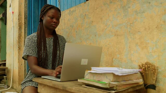 Using internet and technology to learn online, a young woman is getting access to education from her remote village in Kumasi, Ghana in Africa.