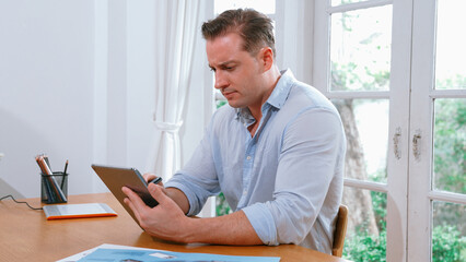 Businessman struggle to solve work problem from home using laptop, sitting on his desk at home...