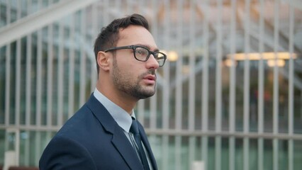 Thoughtful 30-Year-Old French Businessman In Glasses Walking In The City By Office Building - close up tracking shot