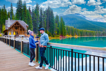 A couple of men and women standing by the lake looking at the mountains,Emerald Lake Yoho National Park Canada British Colombia. a beautiful lake in the Canadian Rockies during the autumn season. 