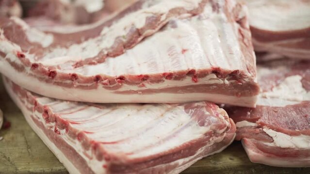 Fresh piece of pork ribs carried by hands of Butcher. Slow motion.
