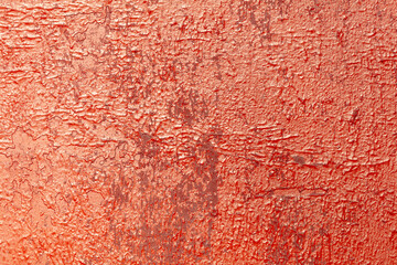 Cracked rusty metal painted with red paint as an abstract background. Texture