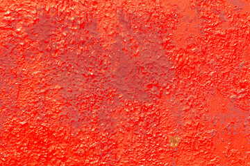 Cracked rusty metal painted with red paint as an abstract background. Texture