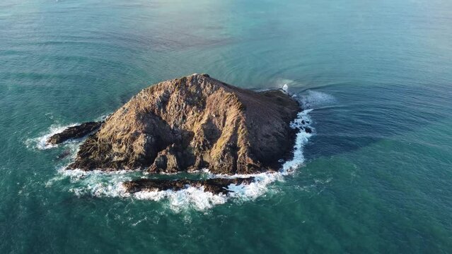 Mokulua Islands offshore from Lanikai/Kailua shot from the sky. Drone pan of Mokulua (Mokes) islands from backside (oceanside) Backlit just after sunrise. Beautiful landscape pan. 