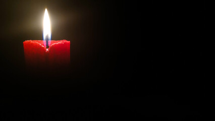 A red candle that has been lit gives warm vibes