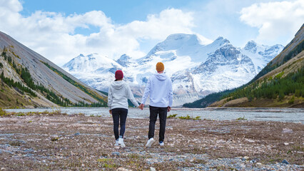 Icefields Parkway with snowy foggy mountains in Jasper Canada Alberta. couple of men and women on a road trip at Icefield Parkway looking out over the mountains covered with snow