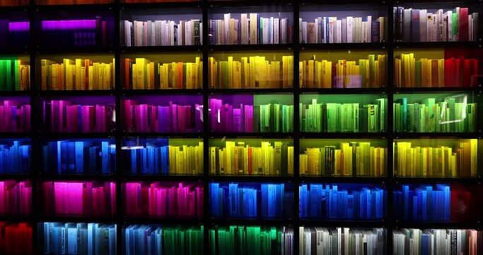 Books of different genres on shelf with multi colored lights