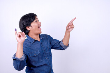 Side view of surprise Asian man pointing aside to the empty space while showing little finger with...