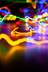 Multi-colored traces of long exposure electric lights on black background....