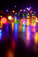 Lights of New Year electric garland reflect from smooth surface....