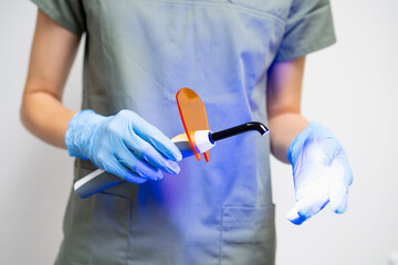 UV lamp in dentists hand in rubber gloves